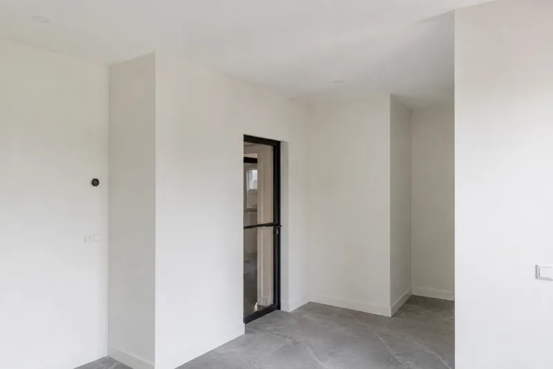 Strak afgewerkte witte muren en plafond in een woonkamer