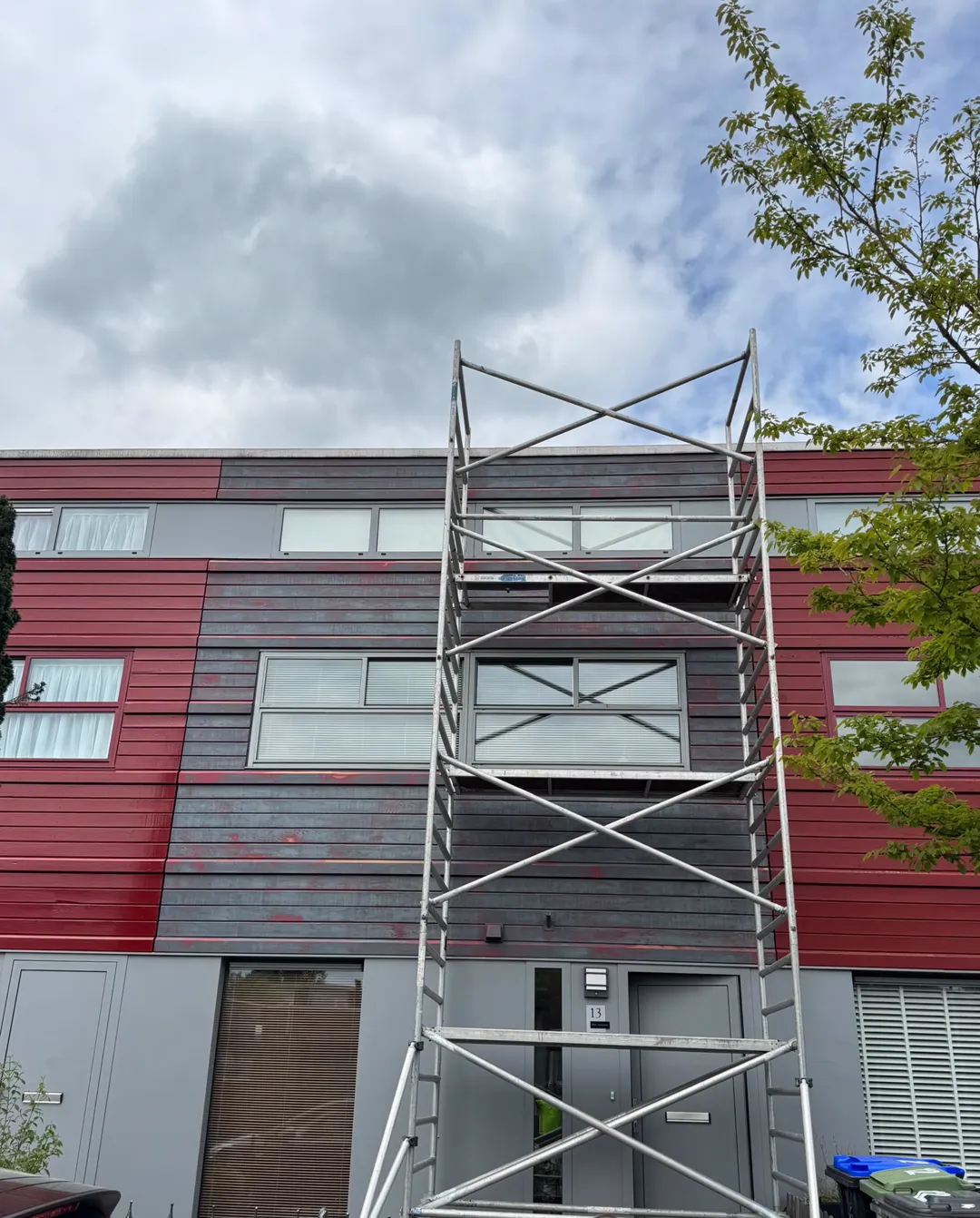 Rolsteiger tegen de houten gevelbekleding aan de Ruischerwaard in Groningen tijdens het buitenschilderwerk